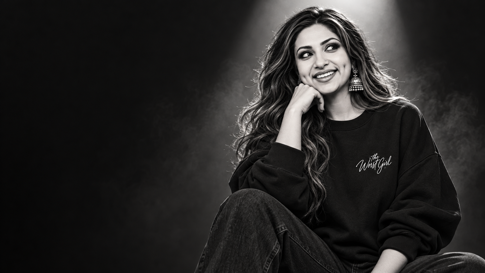 Woman wearing a black The Worst Girl sweatshirt